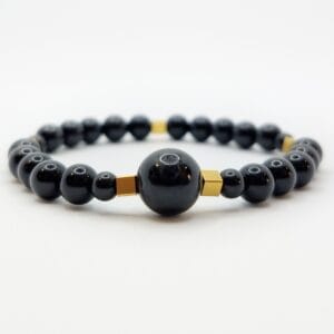 damska bransoletka z czarnym turmalinem z centralnym dużym kamieniem i złotymi przekładkami