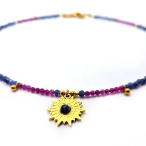 Bliskie ujęcie naszyjnika z intensywnie fioletowych Rubinów, niebieskiego Sodalitu oraz zawieszki Słońce.