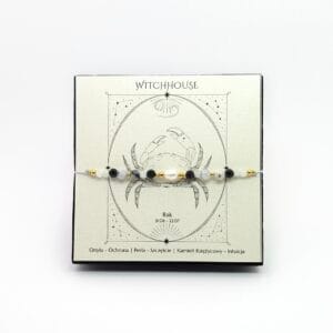 Bransoletka zodiakalna w kolorze złotym dla znaku Rak z onyksu, perły i kamienia księżycowego w pudełku.