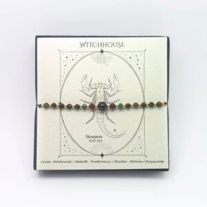 Talizman w kolorze złotym dla znaku Skorpion z kamieniami granat i malachit w ozdobnym pudełku Witchhouse.